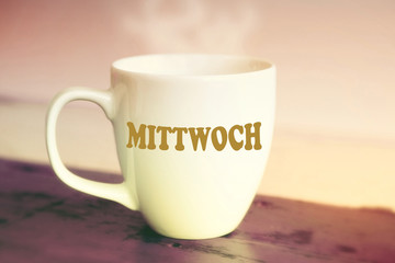closeup of white cup with the german word Wednesday