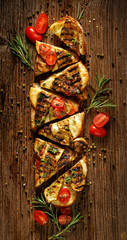 Sandwich with smoked sheep cheese, grilled zucchini, tomatoes and herbs on a wooden rustic table, top view