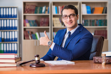 Handsome judge with gavel sitting in courtroom