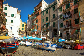 Colorful sailing boats at coast of Riomaggiore town at Cinque Terre National park, Italy