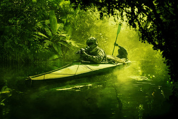 Two special forces operators paddling in the military kayak in the jungle without drawing...
