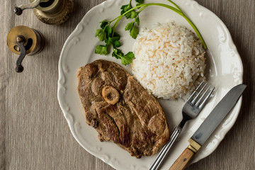 Lamb meat (tandoori) with rice and parsley in white plate.