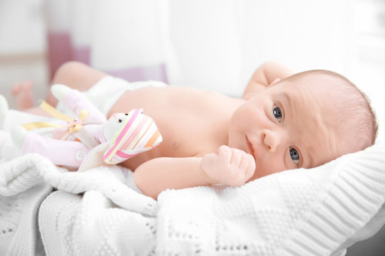 Newborn baby girl, 7 days old, lying on soft  blanket in a basket