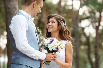 Beautiful wedding couple outdoors on blurred background, close up view