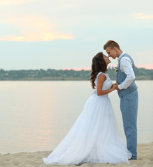 Fototapeta na wymiar Beautiful wedding couple near river