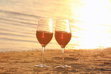 Two glasses of red wine on sea shore