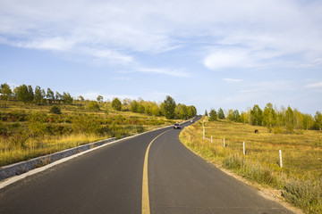 asphalt road on grassland