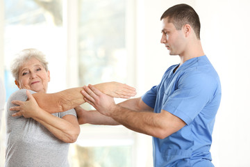 Obraz premium Physiotherapist working with elderly patient in clinic