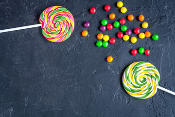 sweets and sugar candies on dark background top view