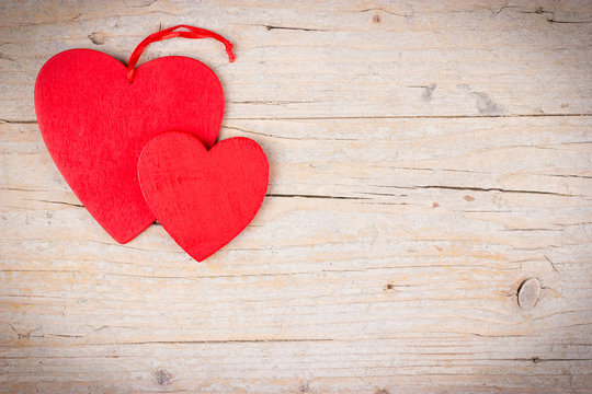 Two red hearts on wooden background