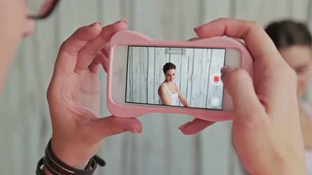 5 shots. Make up artist taking photo of her client with beautiful make-up and elegant hairstyle. White wooden background. Beauty, fashion and technology concept