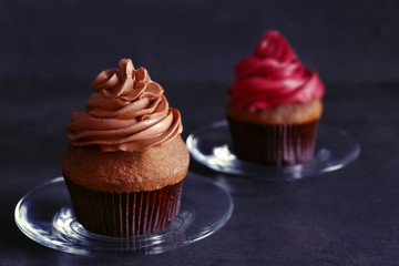Plate with tasty chocolate cupcake on dark table