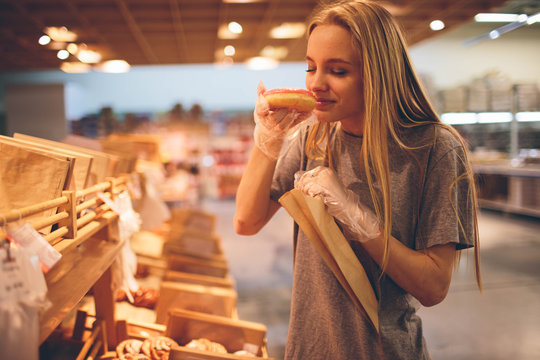 Young woman chooses bread in the store