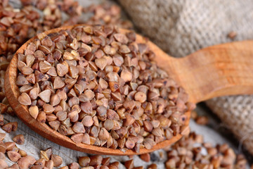 Spoon with brown buckwheat on table