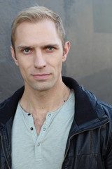 Close up portrait of blond haired handsome male dressed in a black leather jacket