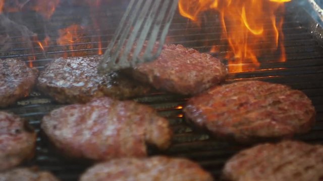 SLOW MOTION: burgers at the grill with fire and smoke