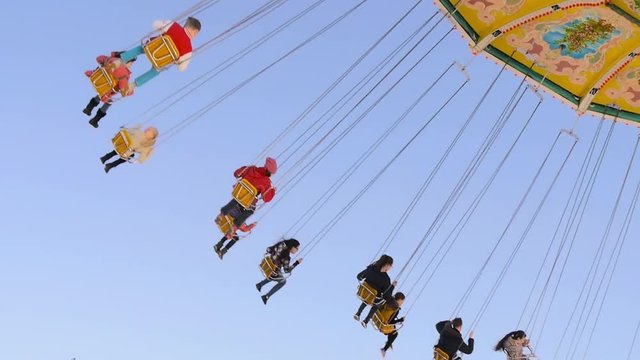 Kinder auf der Schaukel im Freizeitpark