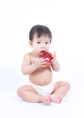 Cute baby with red apple (eating healthy food)