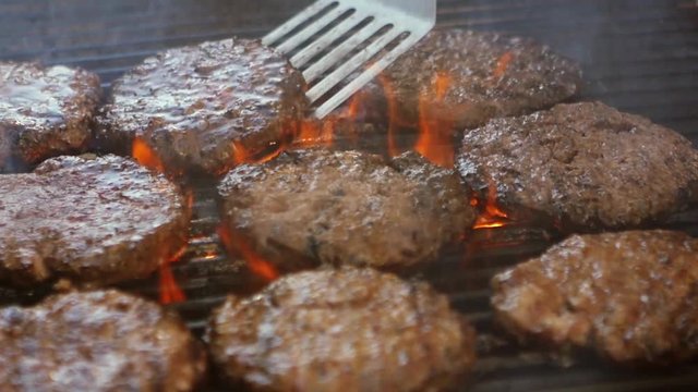 SLOW MOTION: burgers at the grill with fire and smoke