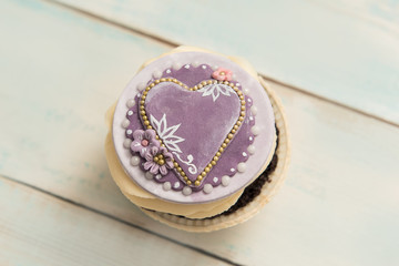 Cupcake with heart on a wooden table