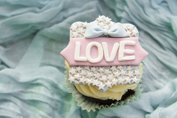 The cupcake with the word love on a blue background. Valentine's day