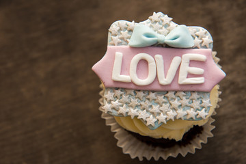 The cupcake with the word love on a brown background. Valentine's day