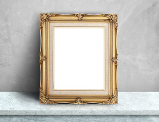 Blank Gold victorian picture frame on white marble table at grey