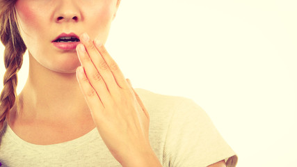 Upset teenage woman with hand close to lips