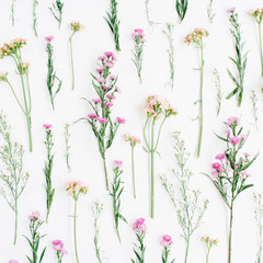 Floral pattern with pink and beige wildflowers, green leaves, branches on white background. Flat lay, top view. Valentine's background
