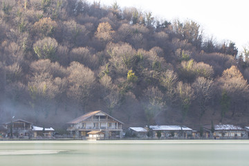 Obraz premium Houses at the foot over a frozen mountain lake.