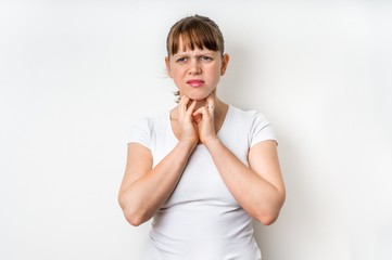 Woman with throat sore is holding her aching throat