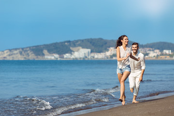 happy couple running on the beach