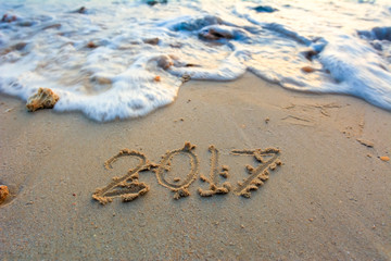 Year 2017 written at the sand beach