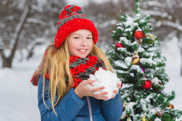 Cute teenager or girl decorating christmas tree outdoor