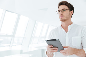 Attractive young man holding tablet computer