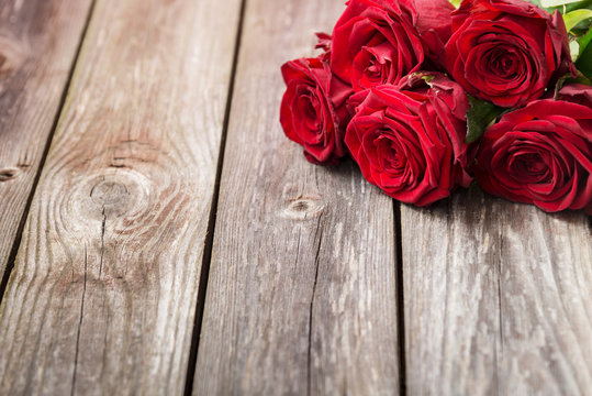 bouquet of red roses on wood background. Valentines Day backgrou