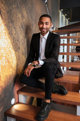 Vertical image of smiling african man on stairs