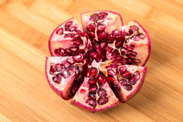 Whole and cut ripe pomegranate isolated on a wood background