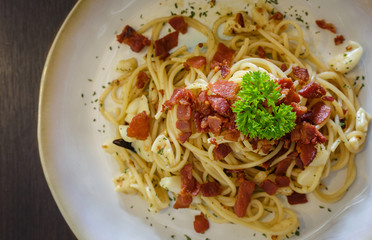 Spaghetti bacon chili garlic on wooden table.