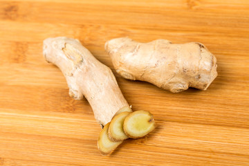 Sliced ginger root with a heart shape isolated on a wood background