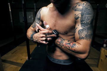 Strong man wearing gymnastics grips before workout
