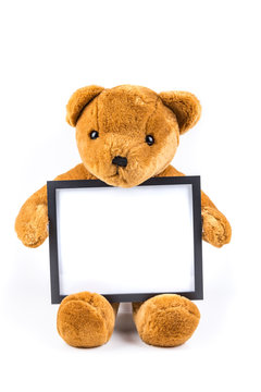 Brown fuzzy teddy bear holding a black frame isolated on a white background