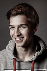 Portrait of happy handsome young man on gray background,