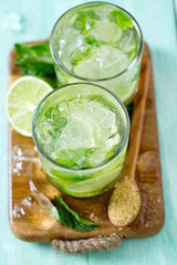 Mojito and ingredients on turquoise wooden surface