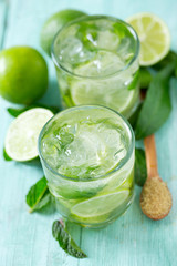 Mojito and ingredients on turquoise wooden surface