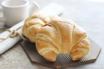 Stock Photo:.Fresh and tasty croissant on old wooden table