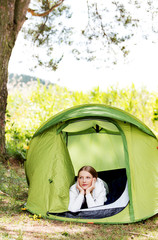 Young woman resting in a tent on the nature