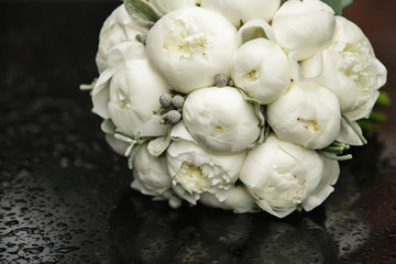 Peony bouquet, white peonies on black table with raindrops in rainy weather. Beautiful bouquet of...