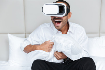 Obraz premium Young African man in virtual reality device on bed