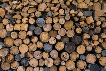 Chopped firewood, stacked woodfuel, fuelwood texture. Natural wooden background.